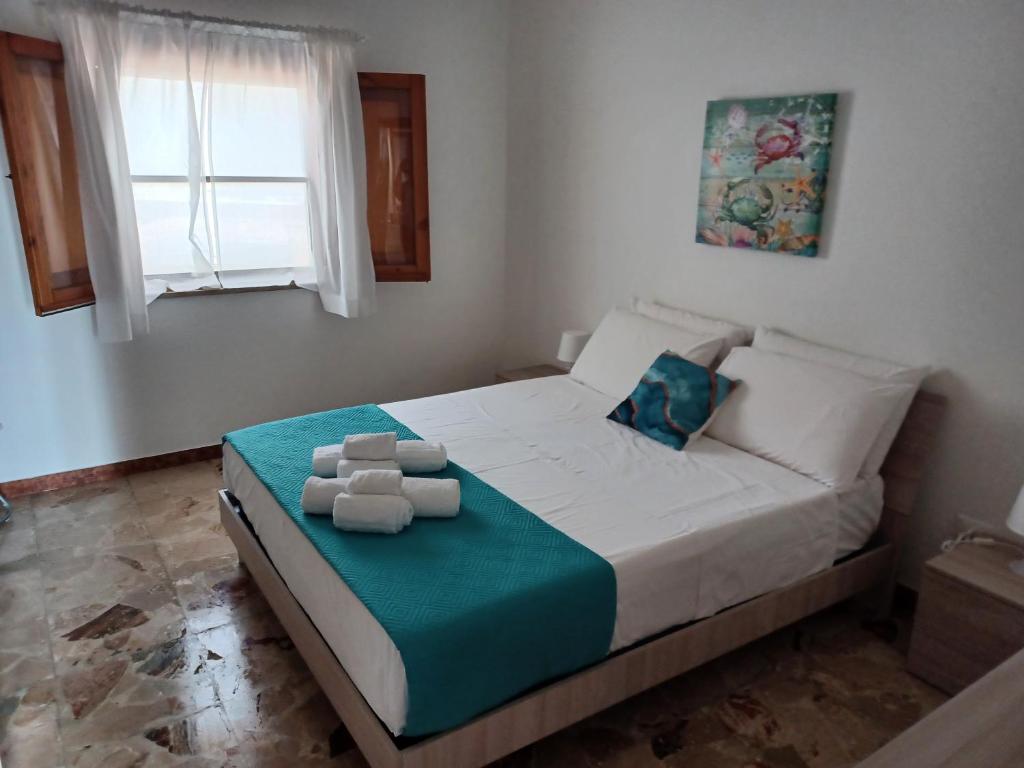 Villa Romana في Leporano Marina: غرفة نوم عليها سرير وفوط
