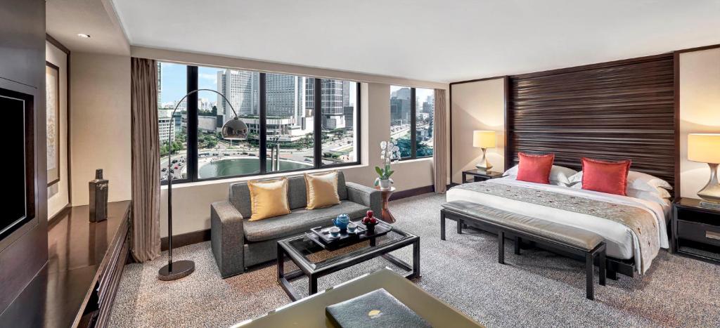 a hotel room with a bed and a large window at Mandarin Oriental, Jakarta in Jakarta