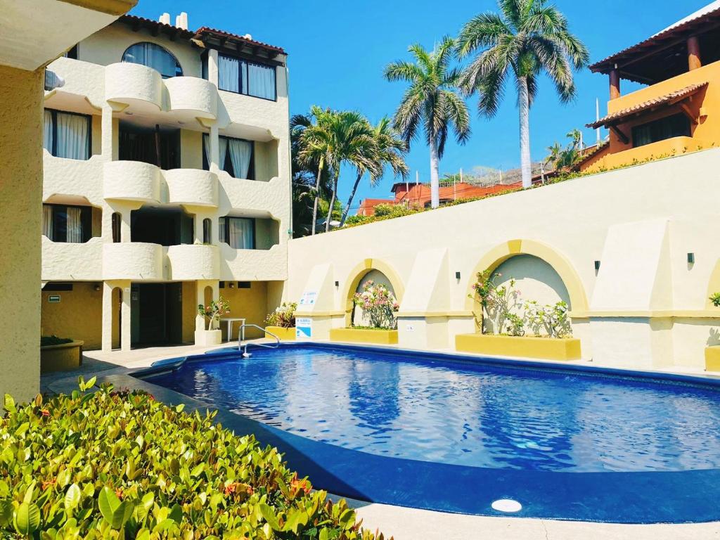 a swimming pool in front of a building at Villas Miramar in Zihuatanejo