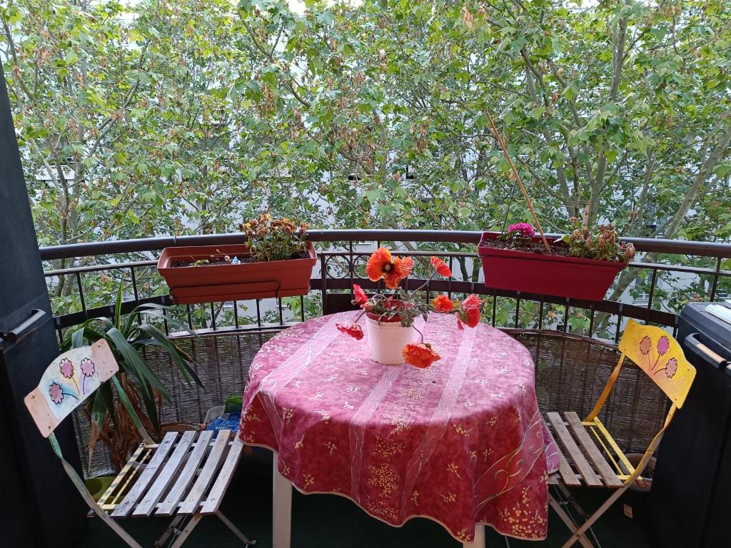 d'une table avec un tissu de table rose et des fleurs sur un balcon dans l'établissement ISSY PORTE DE VERSAILLE Tram T2, à Issy-les-Moulineaux