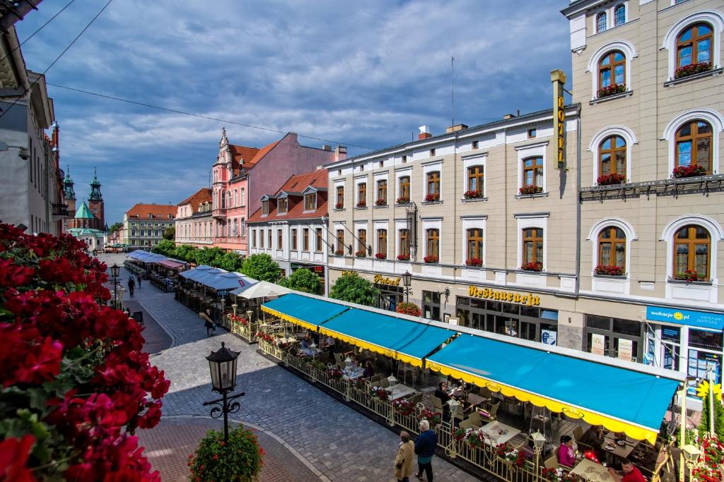 a city street with buildings and people walking around at Pietrak Hotel in Gniezno