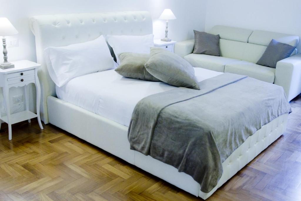 a white bed with pillows and a couch in a room at 3 Inn Ripetta in Rome