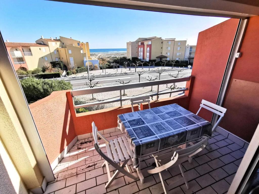 d'une table et de chaises sur un balcon avec vue sur la rue. dans l'établissement Résidence Copacabana - Lumineux appartement deux pièces à Port Leucate. Réf: 1COP_414D MAE-5784, à Port-Leucate