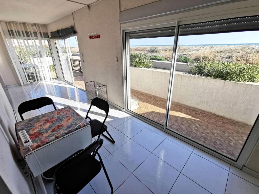 Cette chambre dispose d'une table, de chaises et d'un balcon. dans l'établissement Résidence Les Aigues Marines - Appartement 3 pièces pour 7 personnes avec Wifi face à la mer à Port Leucate en rez de chaussée. réf: 1AM_102 MAE-5854, à Port-Leucate