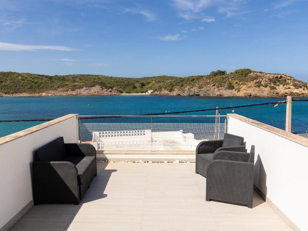 een balkon met stoelen en uitzicht op het water bij Roques5 - Adults Only - House In Es Grau in Es Grau