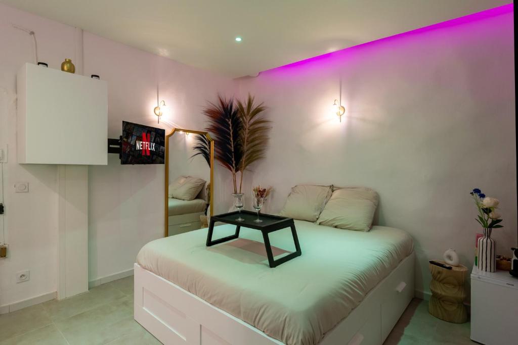 a bedroom with a bed with a table on it at Les nuits d’Ina in Toulon