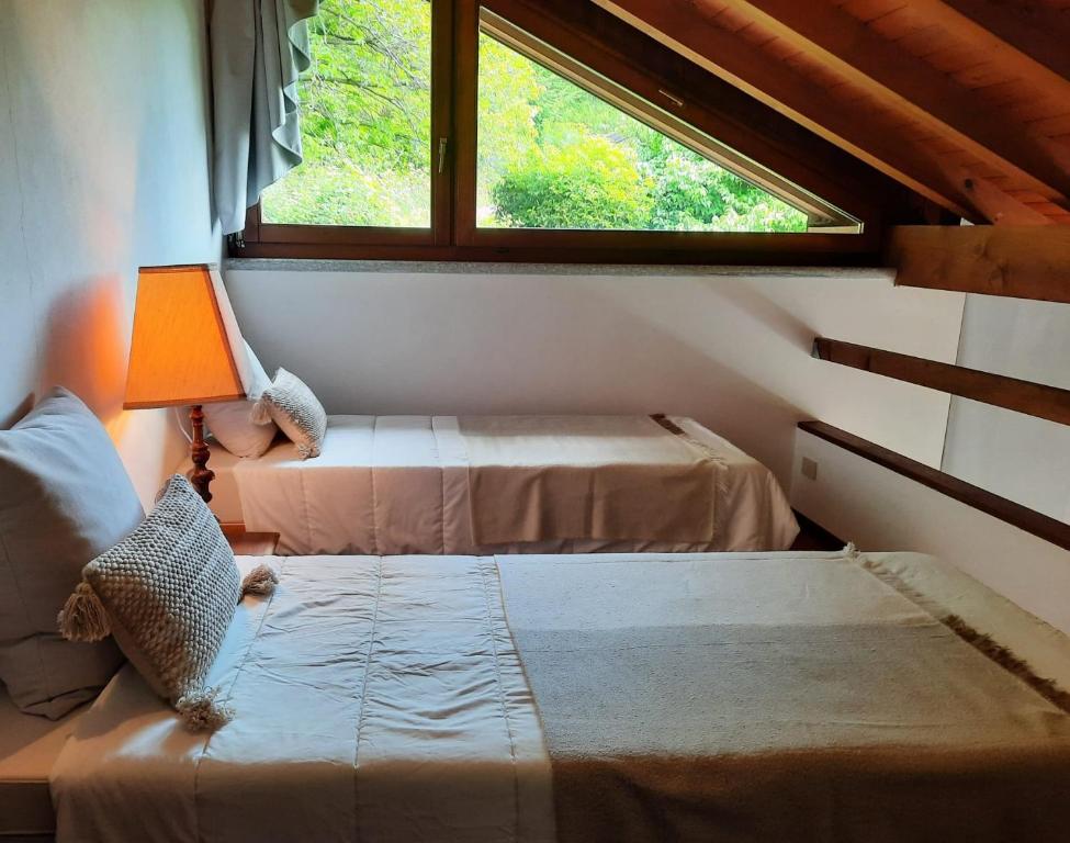 ein kleines Schlafzimmer mit 2 Betten und einem Fenster in der Unterkunft Casa Birtukan in Massino Visconti