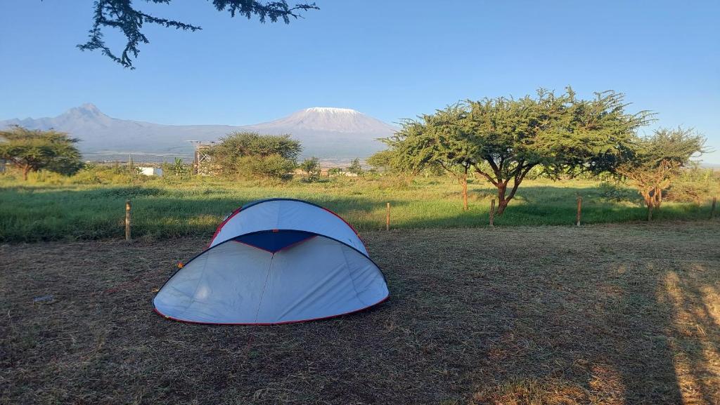 a blue tent on the ground with a mountain in the background at Camp David-Amboseli in Oloitokitok 
