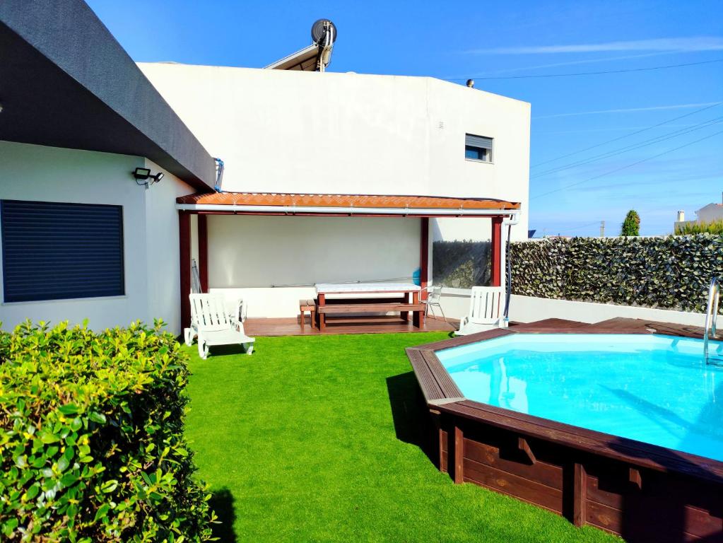un patio trasero con piscina y una casa en Peter Love House en Ericeira