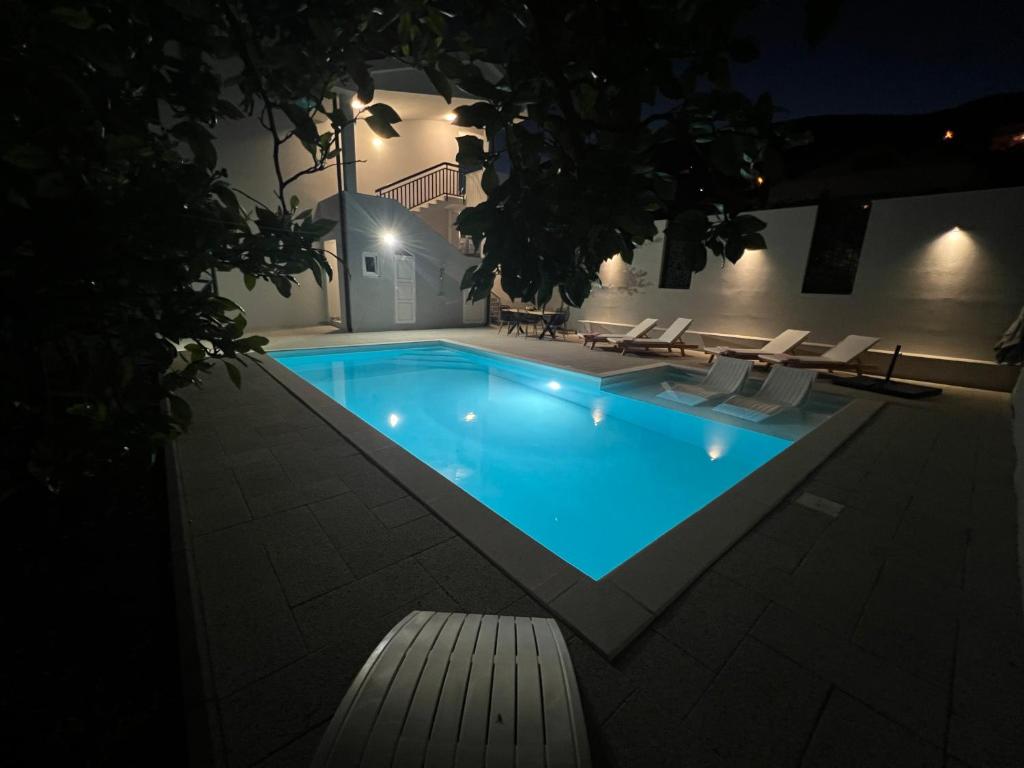 a swimming pool at night with chairs around it at Villa Flumen, Private Pool, Family Villa in Mostar