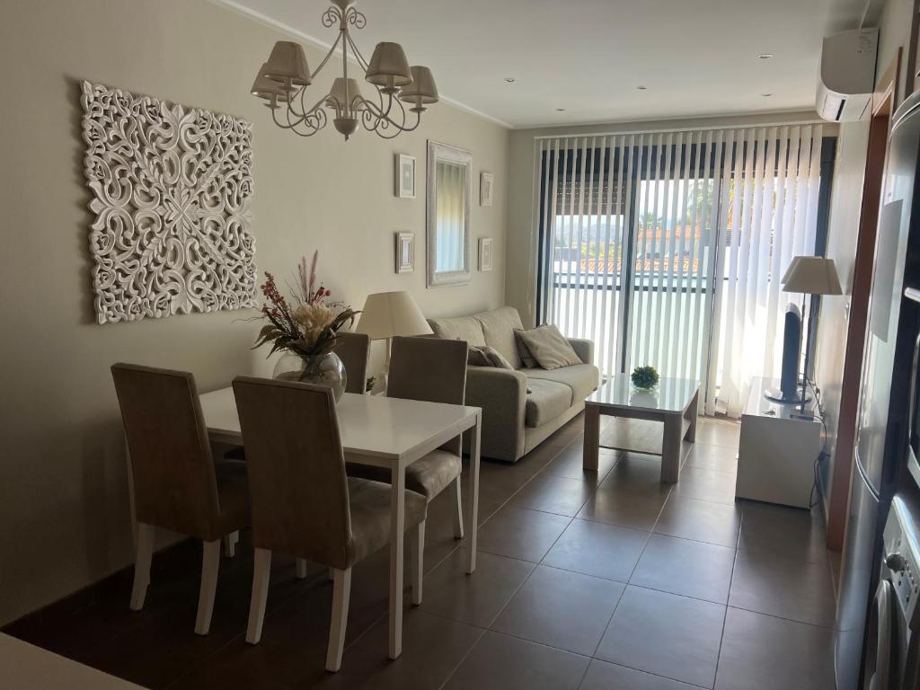 a living room with a table and a couch at MET Apto en Las Dunas, Oliva Nova in Oliva