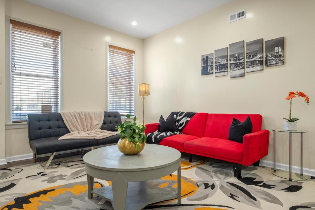 ein Wohnzimmer mit einem roten Sofa und einem Tisch in der Unterkunft Lovely Vacation Home In The Grays Ferry Area in Philadelphia