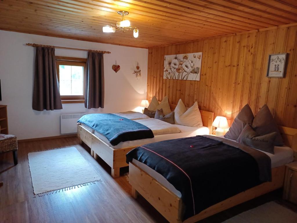 a hotel room with two beds and a couch at Lampererhof in Sankt Johann in Tirol