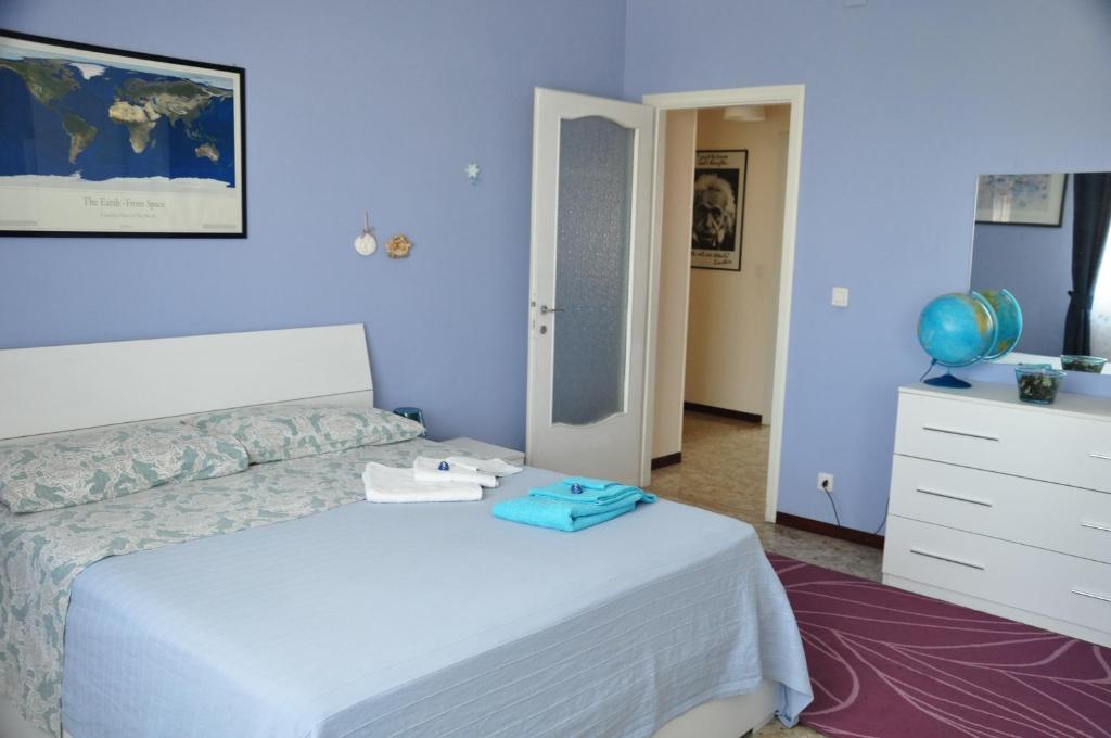 1 dormitorio con 1 cama, vestidor y pared azul en Apartment Montebello, en Parma