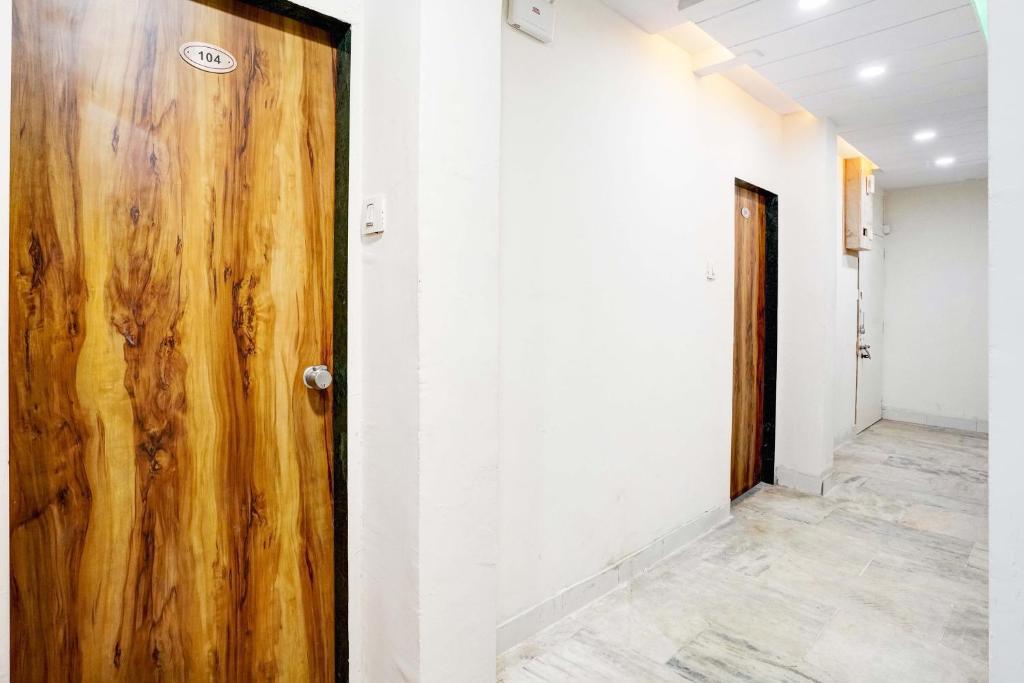 een houten deur in een kamer met een gang bij Hotel Apollo in Ahmedabad