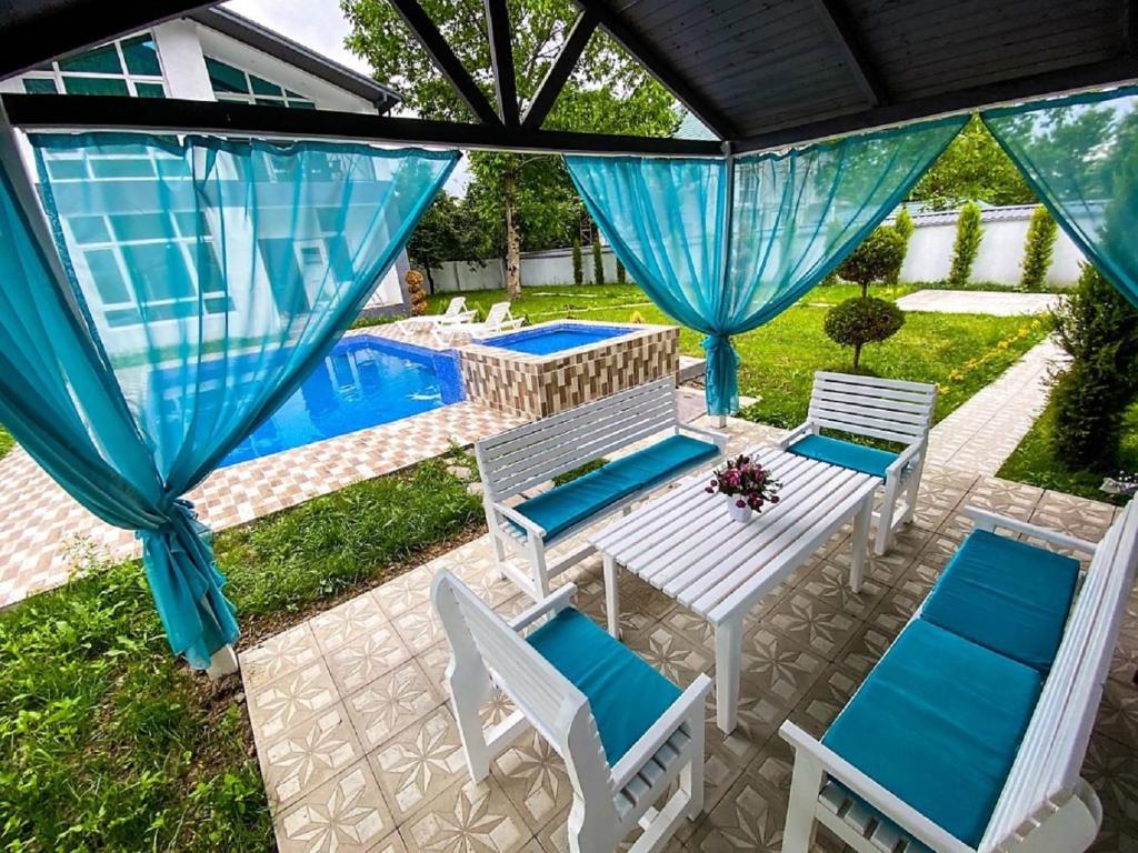 een patio met een tafel en stoelen en een zwembad bij Qafqaz Resort Wonderland in Gabala