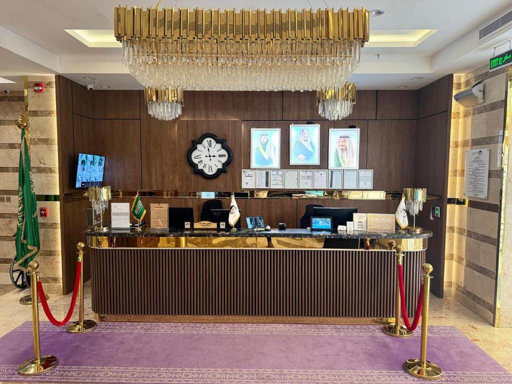 a lobby with a reception desk and a chandelier at Rawabi Garden Inn in Jeddah