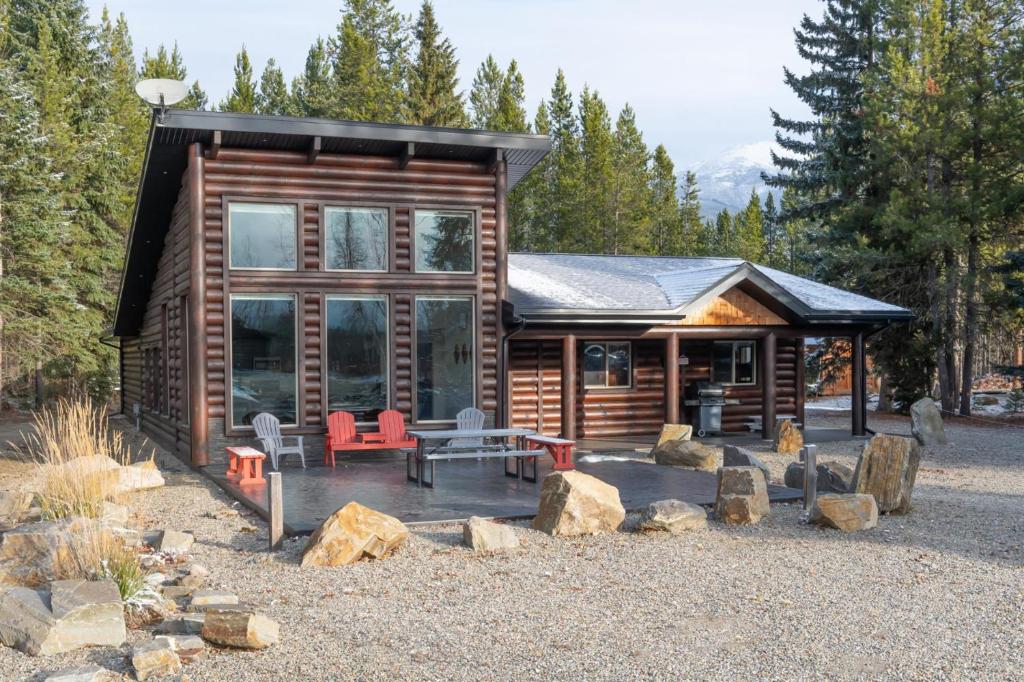 a log cabin with a table and chairs in front of it at Aspen in Valemount