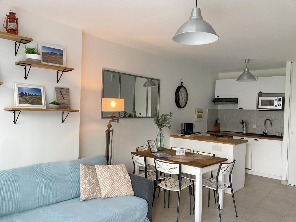 ein Wohnzimmer und eine Küche mit einem blauen Sofa und einem Tisch in der Unterkunft TY DOLMEN DU Plages à pied 2 vélos WIFI in Carnac
