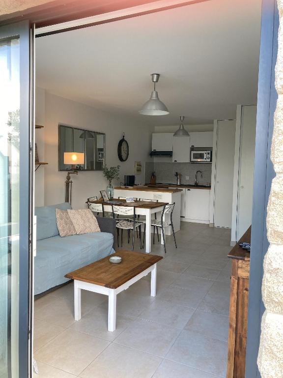 a living room and kitchen with a couch and a table at TY DOLMEN DU - 2 vacanciers - Jardin clos - Petit chien bienvenu - 2 vélos - Plages et Commerces à pied in Carnac