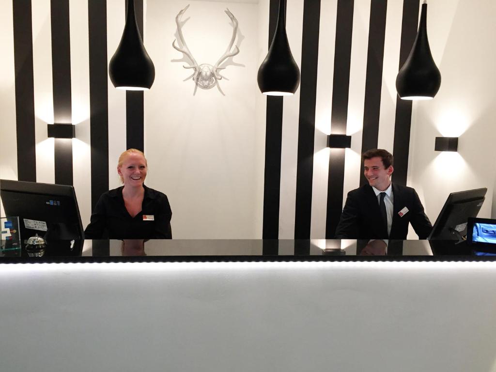 two men and a woman sitting at a table at Hotel Alt Deutz City-Messe-Arena KONTAKTLOSER SELF CHECK-IN in Cologne