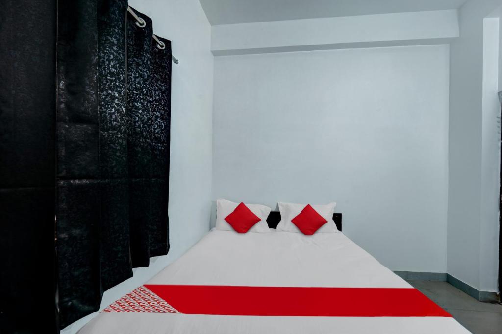 As Hotels & Banquet في Hazārībāg: سرير أبيض مع وسائد حمراء في الغرفة