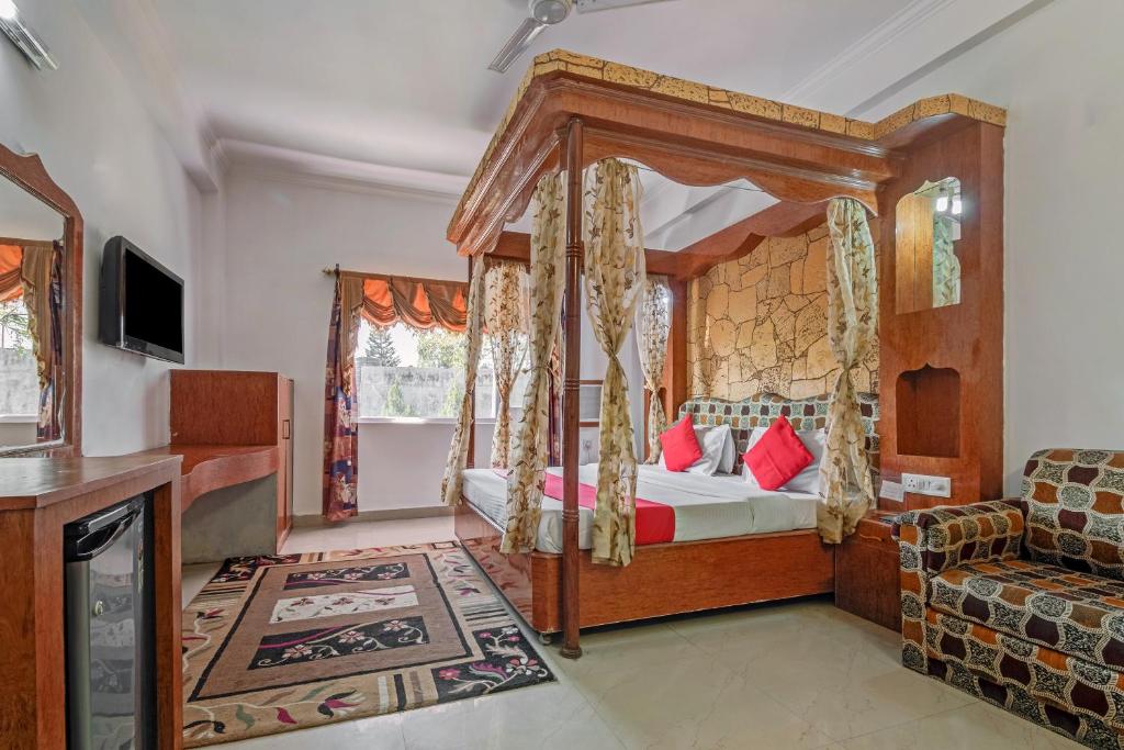a bedroom with a canopy bed and a couch at Collection O Hotel Gordon House in Katra