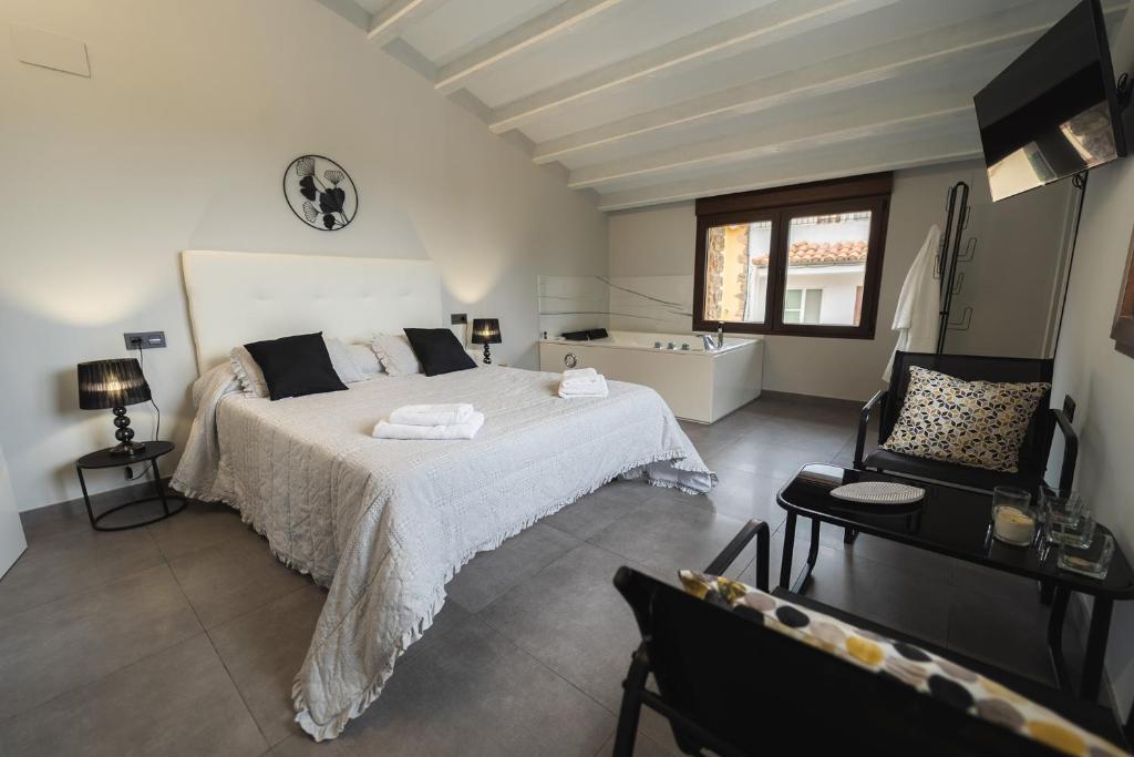 CASA RURAL MENSIN في Villar de Canes: غرفة نوم بسرير كبير وحوض استحمام