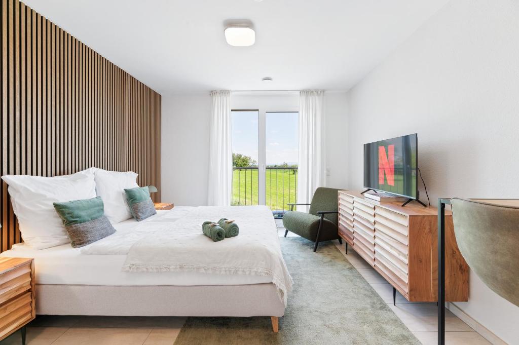- une chambre avec un grand lit et une fenêtre dans l'établissement TheServiced - Design Apartments, à Stuttgart