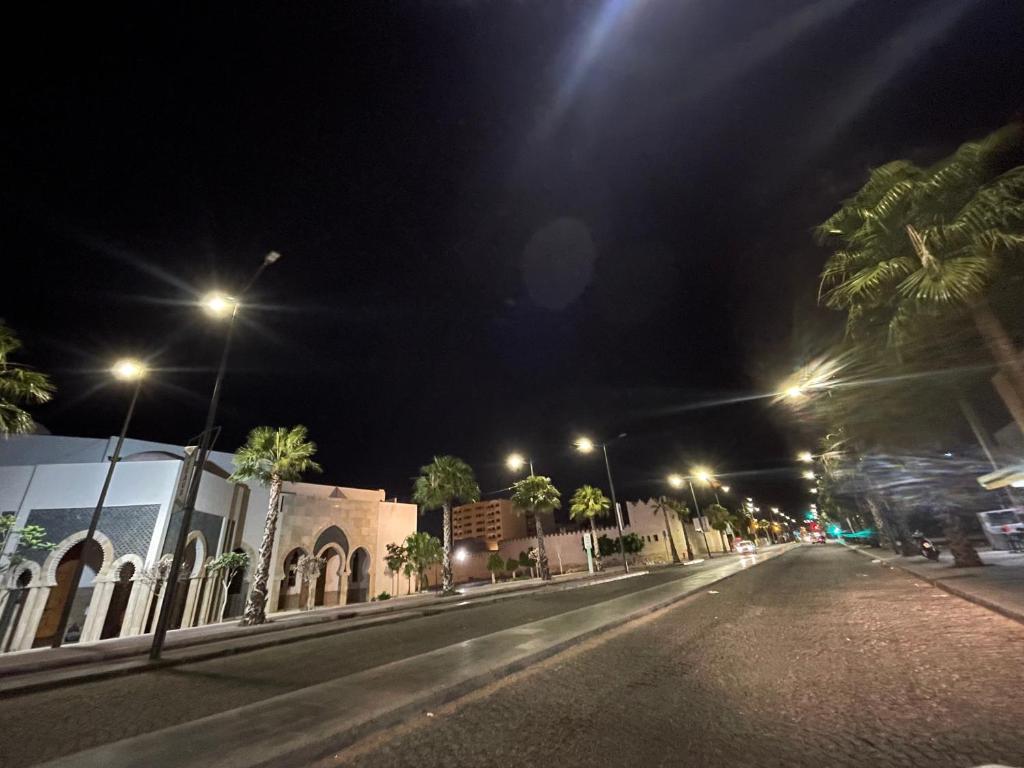 an empty street at night with palm trees and street lights at maison souk agadir in Agadir