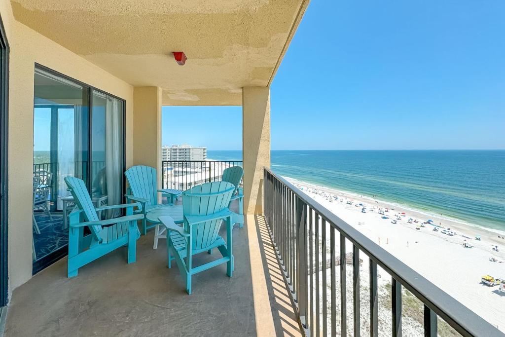 a balcony with blue chairs and the beach at Phoenix 5 Unit 1417 in Orange Beach