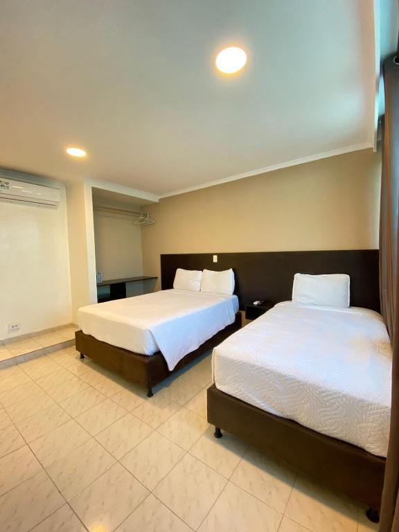 Postel nebo postele na pokoji v ubytování Holiday Sai Hotel