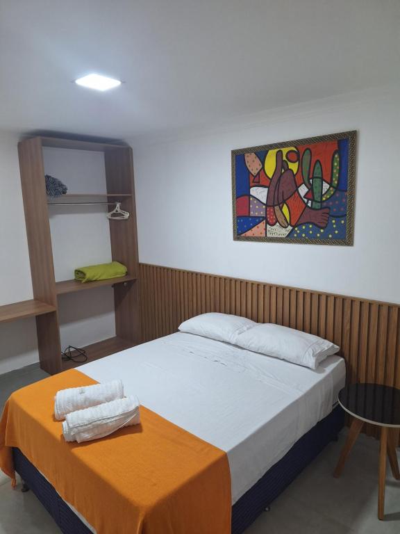 um quarto com uma cama e um quadro na parede em Morada do Francês na Praia do Francês