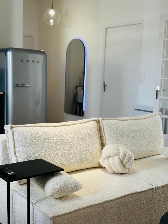 - un salon avec un canapé blanc et un miroir dans l'établissement Appartement Jules Ferry - centre, à Saumur