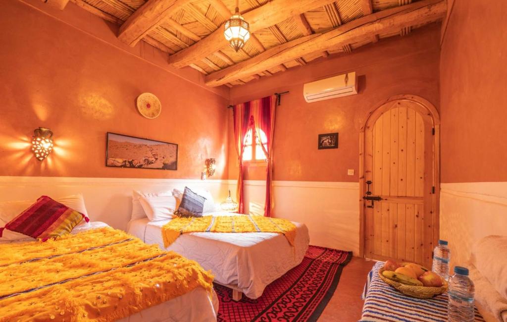 a bedroom with two beds and a window at Hotel Atlas Gorge Dades in Boumalne