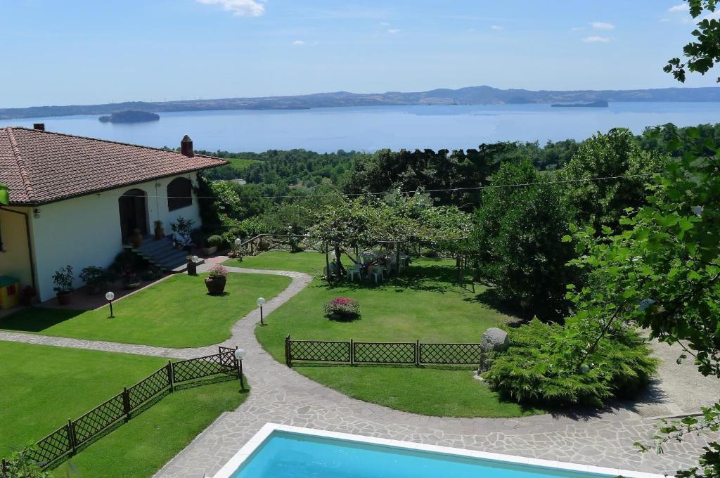a house with a swimming pool and a view of the water at La Guardata in Montefiascone