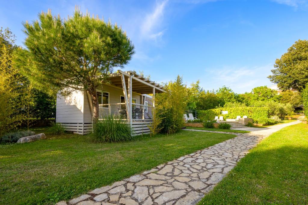a house with a stone path in front of it at Mobile Homes Peškera in Pula