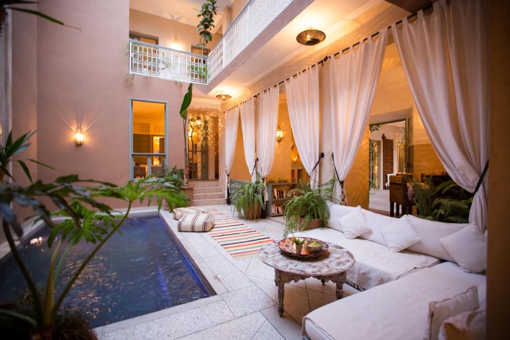 a living room with a white couch and a pool at Riad Olema et Spa in Marrakech