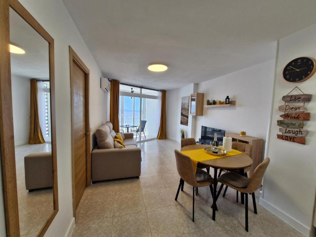 ein Esszimmer und ein Wohnzimmer mit Tisch und Stühlen in der Unterkunft Beach View Las Americas in Playa de las Americas