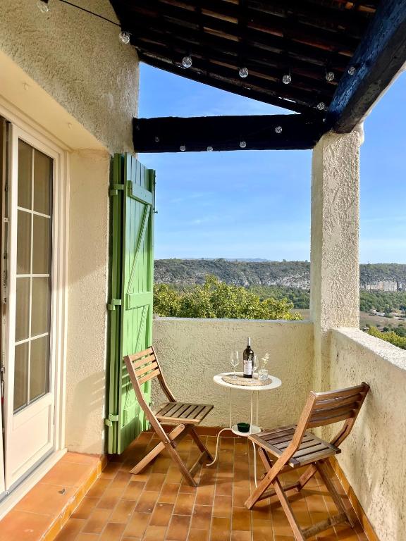 un patio avec deux chaises et une table sur un balcon dans l'établissement Villa Hill avec vue panoramique - Provence Verdon, à Quinson