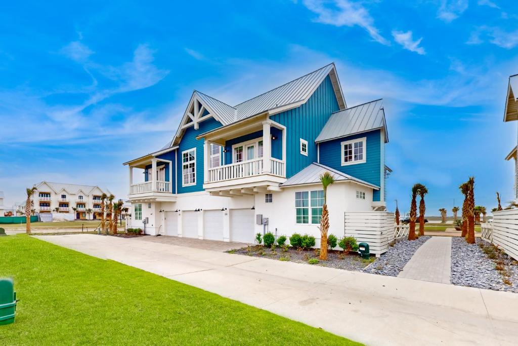 a blue and white house with a driveway at Mimosa Manor in Port Aransas