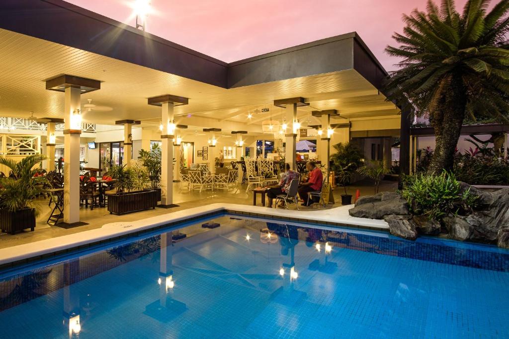 a large swimming pool in a building with a restaurant at Fiji Gateway Hotel in Nadi