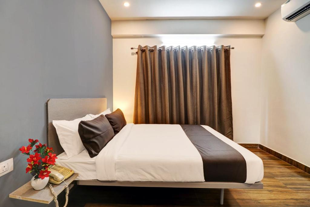 1 dormitorio con cama y cortina en Townhouse XOTEL en Bangalore
