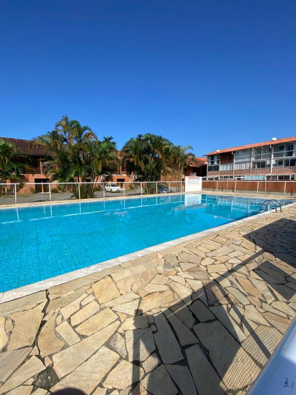 a large swimming pool with blue water at Apartamento em Ubatuba - Condomínio Ville II - 300 metros da Praia do Sapê - Maranduba in Ubatuba