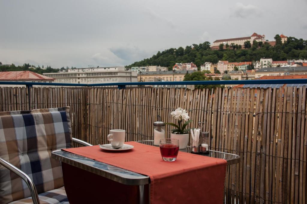 uma mesa numa varanda com vista para a cidade em Hotel Omega Brno em Brno