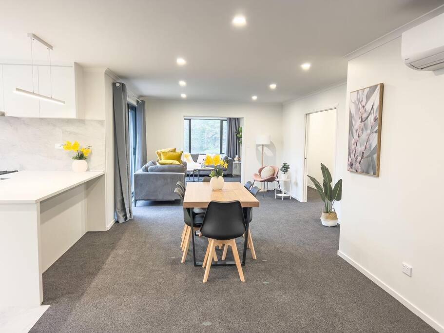 eine Küche und ein Wohnzimmer mit einem Tisch im Zimmer in der Unterkunft Rotorua Sunshine Brand New 4 Bedroom house in Rotorua