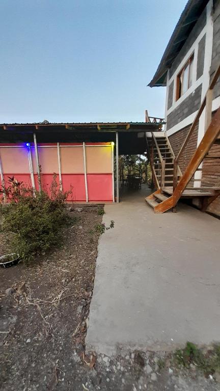 un edificio con un garaje colorido con una escalera en Hospedaje Bananas, en Altagracia