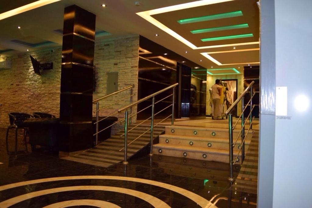a staircase in a building with people walking down it at Desert Palm Aparthotel in Al Nairyah