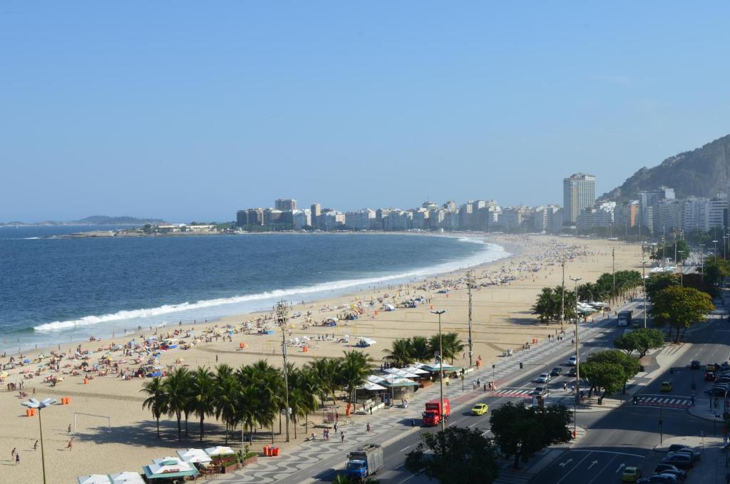 uma praia com muita gente e o oceano em Hotel Rio Lancaster no Rio de Janeiro