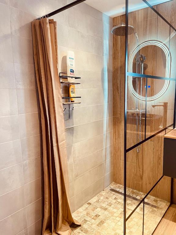 une douche avec une porte vitrée dans une salle de bain dans l'établissement Havre de paix à Narbonne, à Narbonne